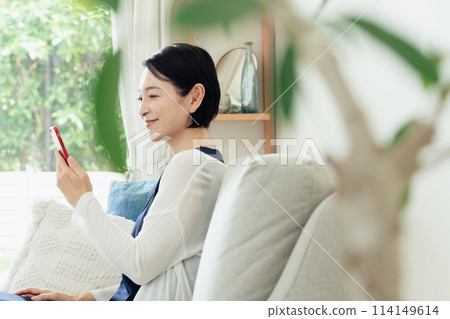 A middle-aged woman operating a smartphone 114149614