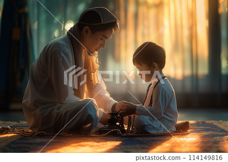 Father and son reading Islamic holy bible Quran together in living room at home 114149816