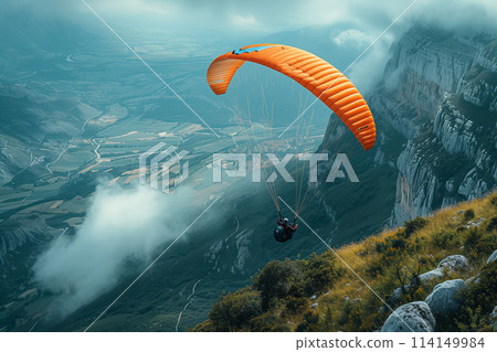 Person Paragliding Above Mountains Amid Clouds 114149984