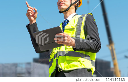 一位男性商人是現場主管,戴著頭盔,做確認工作 一位男性商人是現場主管,戴著頭盔,做確認工作 114150183