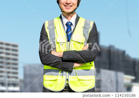 A male site supervisor wearing a helmet (construction work) A male site supervisor wearing a helmet (construction work) 114150186