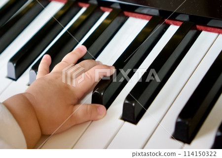Child's hands playing the piano 114150322