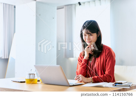 客廳裡,一名 30 多歲的女士攤開筆記型電腦,一臉嚴肅地工作。 客廳裡,一名 30 多歲的女士攤開筆記型電腦,一臉嚴肅地工作。 114150766