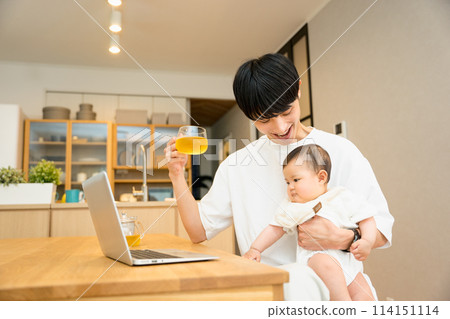 A man in his 20s or 30s working on a laptop while nursing a baby at a desk in the living room A man in his 20s or 30s working on a laptop while nursing a baby at a desk in the living room 114151114