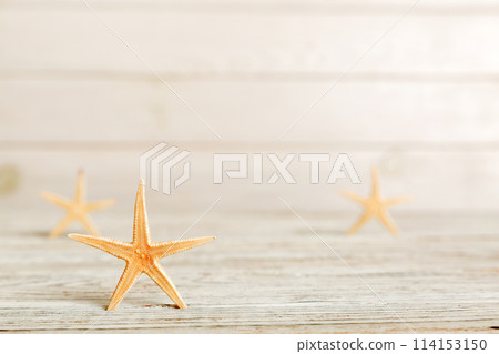 Summer time concept with sea shells or starfish on a table background with copy space for text Summer time concept with sea shells or starfish on a table background with copy space for text 114153150