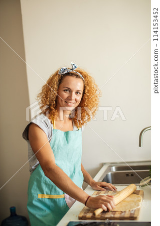 Young mom and little daughter smiling while baking in kitchen at home Young mom and little daughter smiling while baking in kitchen at home 114153452