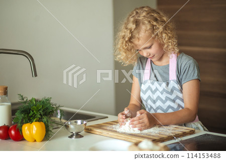Woman and cute daughter cooking on kitchen, making dough for birthday party. Woman and cute daughter cooking on kitchen, making dough for birthday party. 114153488