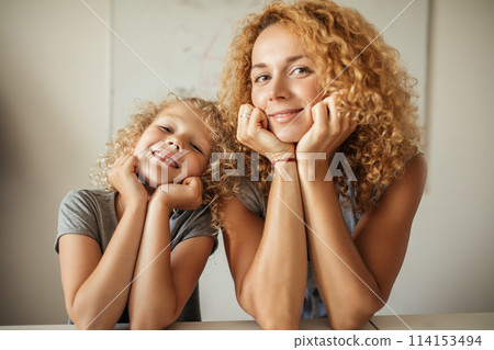 Smiling Mother and her adorable daughter looking at camera. Smiling Mother and her adorable daughter looking at camera. 114153494