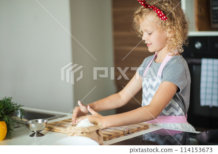 Woman and cute daughter cooking on kitchen, making dough for birthday party. Woman and cute daughter cooking on kitchen, making dough for birthday party. 114153673
