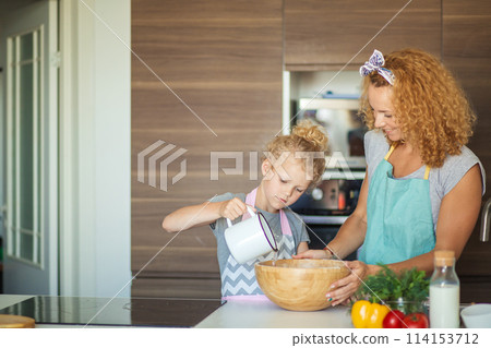 Little daughter helping mother baking in kitchen, family and cooking 114153712