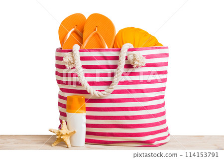Stylish bag with beach accessories . Summer holiday concept. Top view of beach bag with sunscreen cream with space for text 114153791