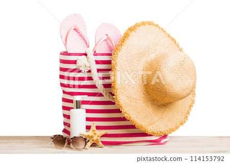 Stylish bag with beach accessories . Summer holiday concept. Top view of beach bag with sunscreen cream with space for text Stylish bag with beach accessories . Summer holiday concept. Top view of beach bag with sunscreen cream with space for text 114153792