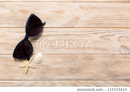 sunglasses with seashell lying on table background. Sunglasses on summer background. Top view flat lay with copy space for text sunglasses with seashell lying on table background. Sunglasses on summer background. Top view flat lay with copy space for text 114153814