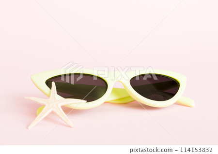 sunglasses with seashell lying on table background. Sunglasses on summer background. Top view flat lay with copy space for text 114153832