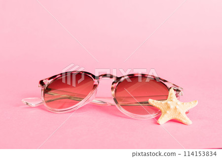 sunglasses with seashell lying on table background. Sunglasses on summer background. Top view flat lay with copy space for text 114153834