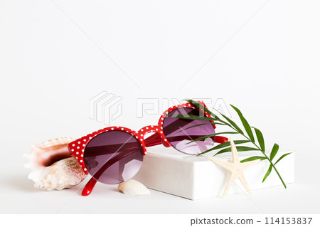 sunglasses with seashell lying on table background. Sunglasses on summer background. Top view flat lay with copy space for text 114153837
