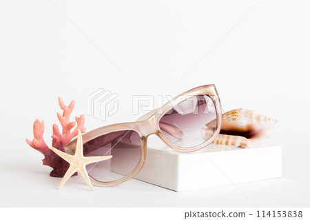 sunglasses with seashell lying on table background. Sunglasses on summer background. Top view flat lay with copy space for text 114153838
