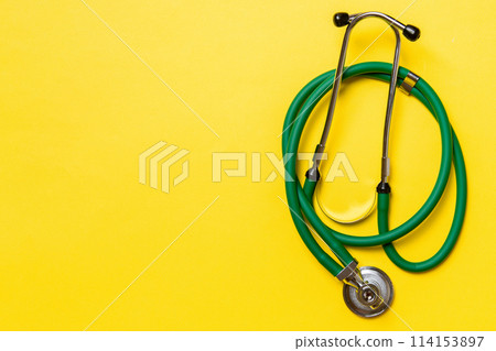 Top view of green medical stethoscope on colorful background with copy space. Medicine equipment concept Top view of green medical stethoscope on colorful background with copy space. Medicine equipment concept 114153897