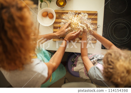 Top view of woman and little daughter making cookies while cooking on kitchen. 114154398