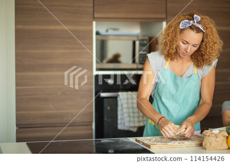 Woman and cute daughter cooking on kitchen, making dough for birthday party. 114154426