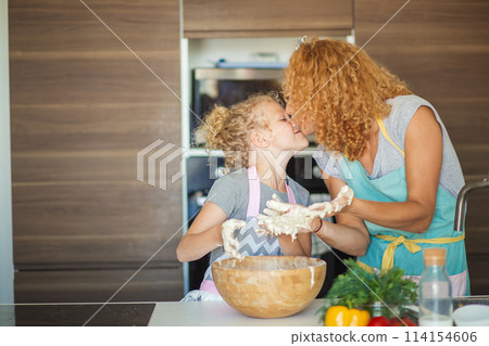 Mother and child daughter girl having fun while making dinner at the kitchen. Mother and child daughter girl having fun while making dinner at the kitchen. 114154606