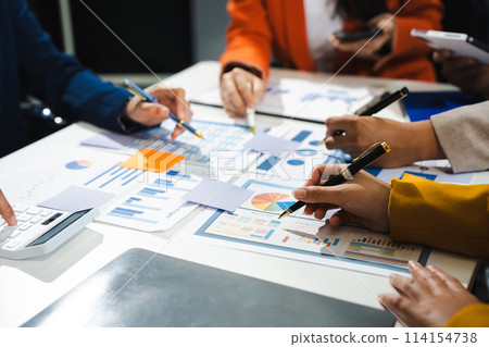 Business, technology and office concept - business team with laptop, tablet pc computer and papers having discussion in modern office. 114154738