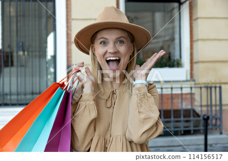 Girl, blonde, with paper bags, on the street. Girl, blonde, with paper bags, on the street. 114156517