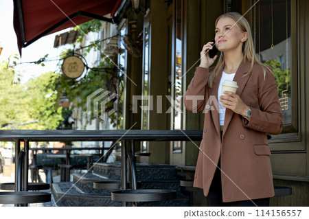 A girl in a business suit with a phone. 114156557