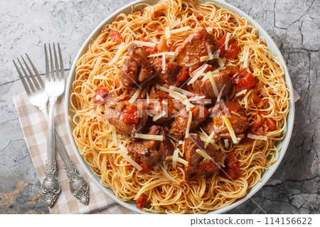 Kokkinisto is s simple beef stew with tomatoes and red wine with pasta spaghetti closeup on the plate. Horizontal top view 114156622
