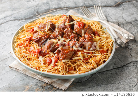Stewed beef in a spicy wine tomato sauce served with spaghetti close-up in a plate. Horizontal Stewed beef in a spicy wine tomato sauce served with spaghetti close-up in a plate. Horizontal 114156636