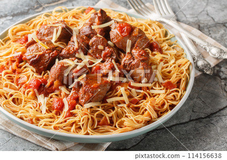 Kokkinisto is s simple beef stew with tomatoes and red wine with pasta spaghetti closeup on the plate. Horizontal Kokkinisto is s simple beef stew with tomatoes and red wine with pasta spaghetti closeup on the plate. Horizontal 114156638