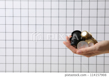 Coffee capsules in hand on light background, space for text Coffee capsules in hand on light background, space for text 114157908