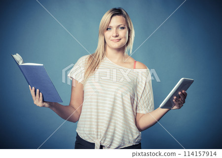 woman with traditional book and e-book reader tablet 114157914