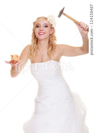 Woman bride with hammer about to smash piggy bank 114158487