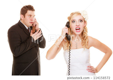 Wedding. Angry bride and groom talking on phone 114158572