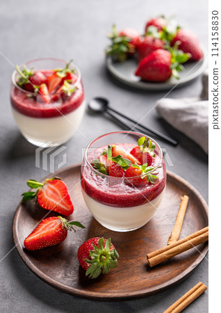 Strawberry and cream panna cotta in glasses with fresh berries on a wooden plate Strawberry and cream panna cotta in glasses with fresh berries on a wooden plate 114158830