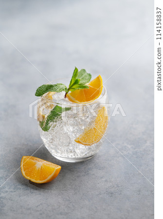 Lemonade tonic drink with fresh lemon, mint and ice on a light background. 114158837