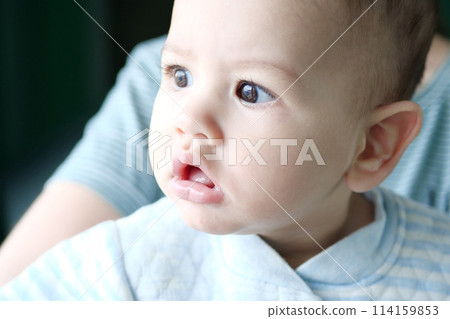 Happy newborn baby makes a funny face. Portrait of a crawling baby in his room close up Happy newborn baby makes a funny face. Portrait of a crawling baby in his room close up 114159853