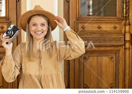 A beautiful girl with a camera on the street. A beautiful girl with a camera on the street. 114159900