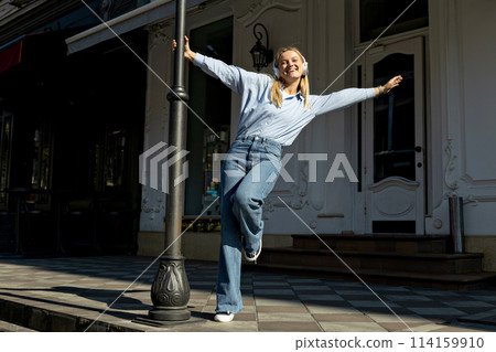 Girl in headphones on the street, close-up portrait. 114159910