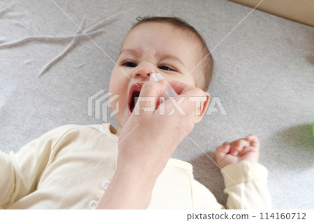 Mother dripping nasal drops for her son. Baby healthcare concept top view Mother dripping nasal drops for her son. Baby healthcare concept top view 114160712