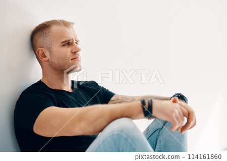 Tired man sitting on the floor Tired man sitting on the floor 114161860