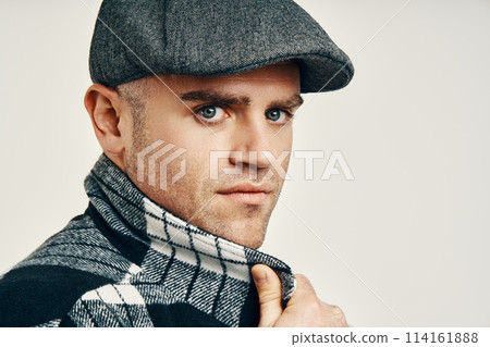 Trendy man in tweed hat over soft white background with copy space Trendy man in tweed hat over soft white background with copy space 114161888