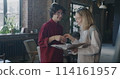 People colleagues shaking hands checking business documents and talking standing in creative office together. Start-up and coworking concept. 114161957