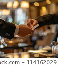 Efficient Hospitality: Guest Completes Check-In Process with Hotel Clerk in Lobby 114162029