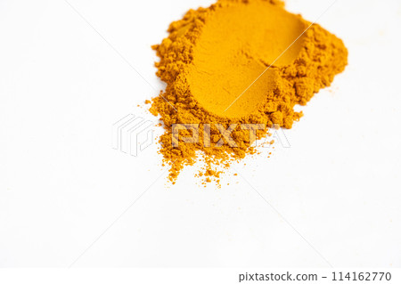 A smear of turmeric on a white background, top view A smear of turmeric on a white background, top view 114162770