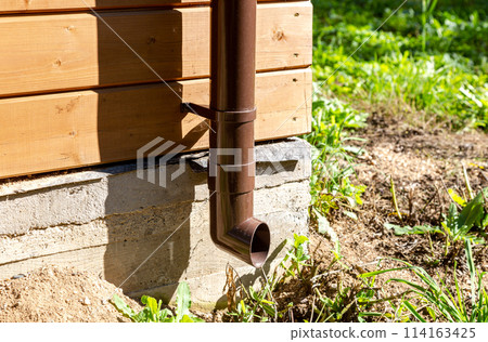 The new plastic rainwater drain pipe on a wooden house The new plastic rainwater drain pipe on a wooden house 114163425
