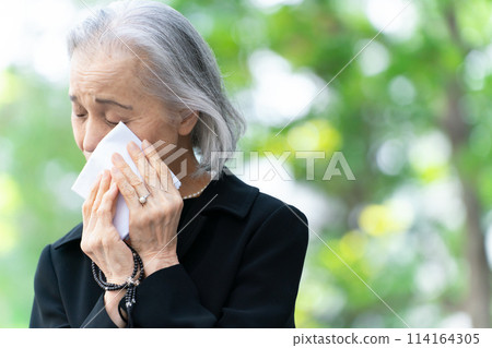 Woman in mourning clothes crying handkerchief 114164305