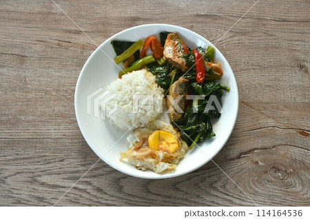 spicy stir fried Chinese kale with fish can in tomato sauce topping egg on rice spicy stir fried Chinese kale with fish can in tomato sauce topping egg on rice 114164536