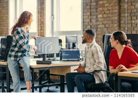 A diverse group of young business individuals congregates in a modern startup coworking center, embodying collaborative innovation and a dynamic atmosphere 114165385